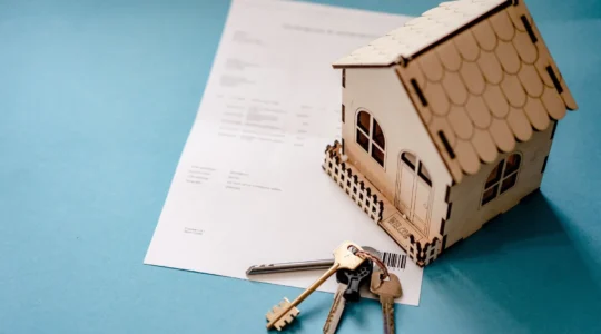 Miniatur Haus mit Schlüssel und Vertrag